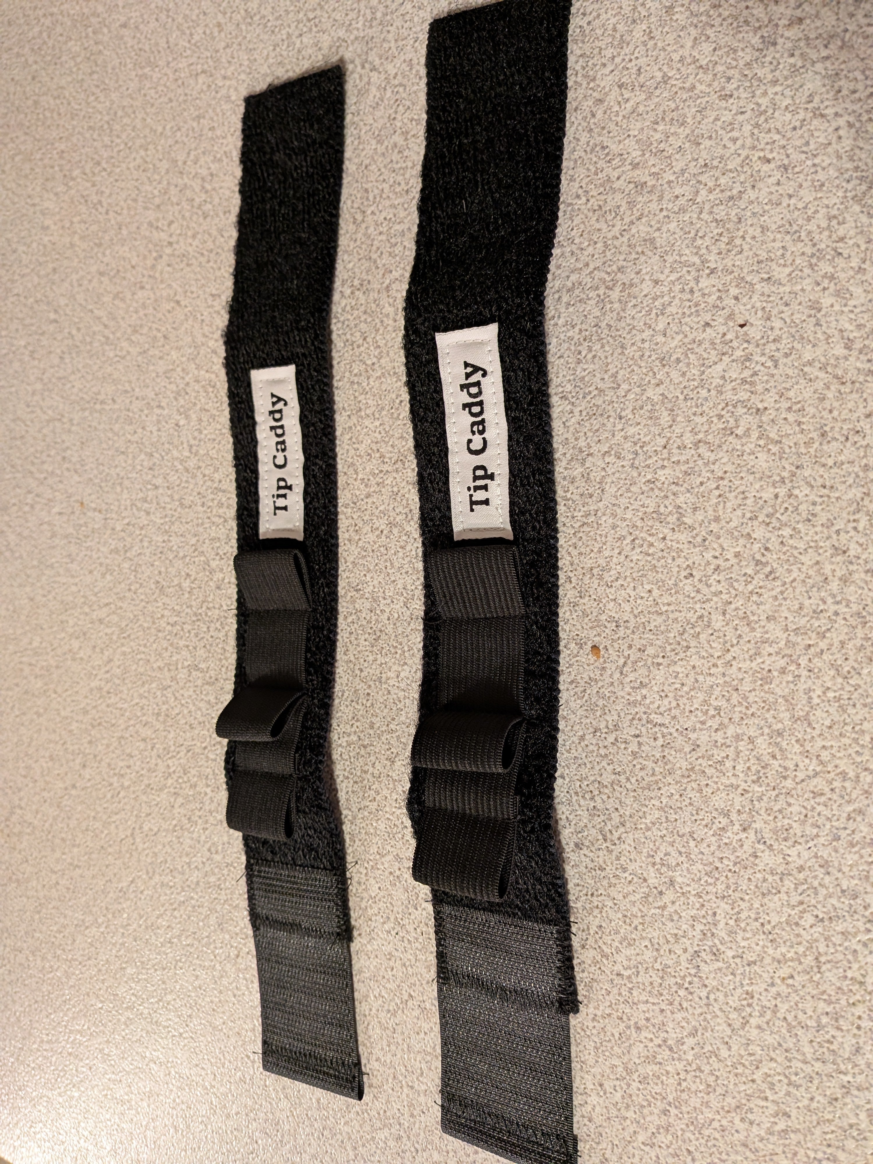 Two black tip caddy straps with hand  stitched labels         